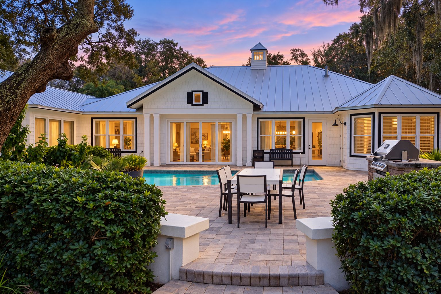 A house with a swimming pool, patio furniture, and a barbecue area.