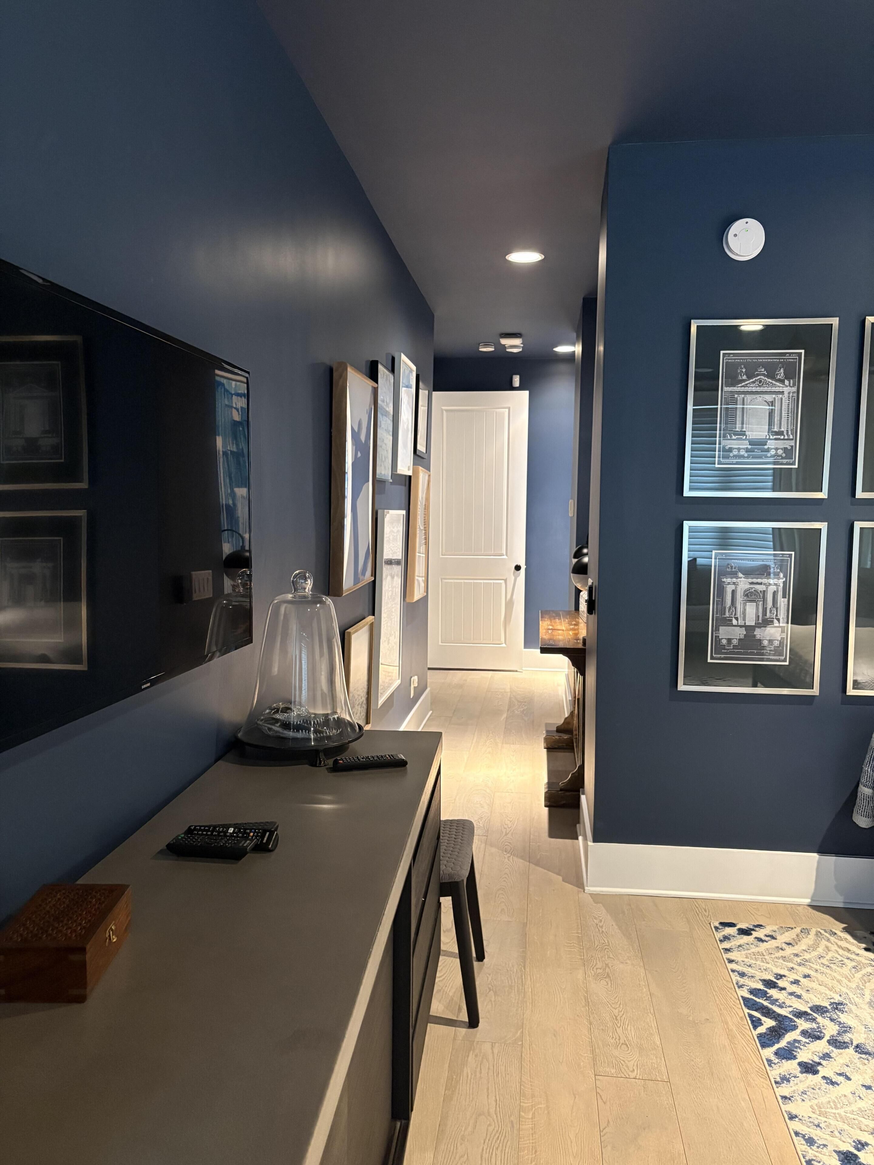 A modern kitchen with a countertop, a coffee machine, and a door leading to another room.