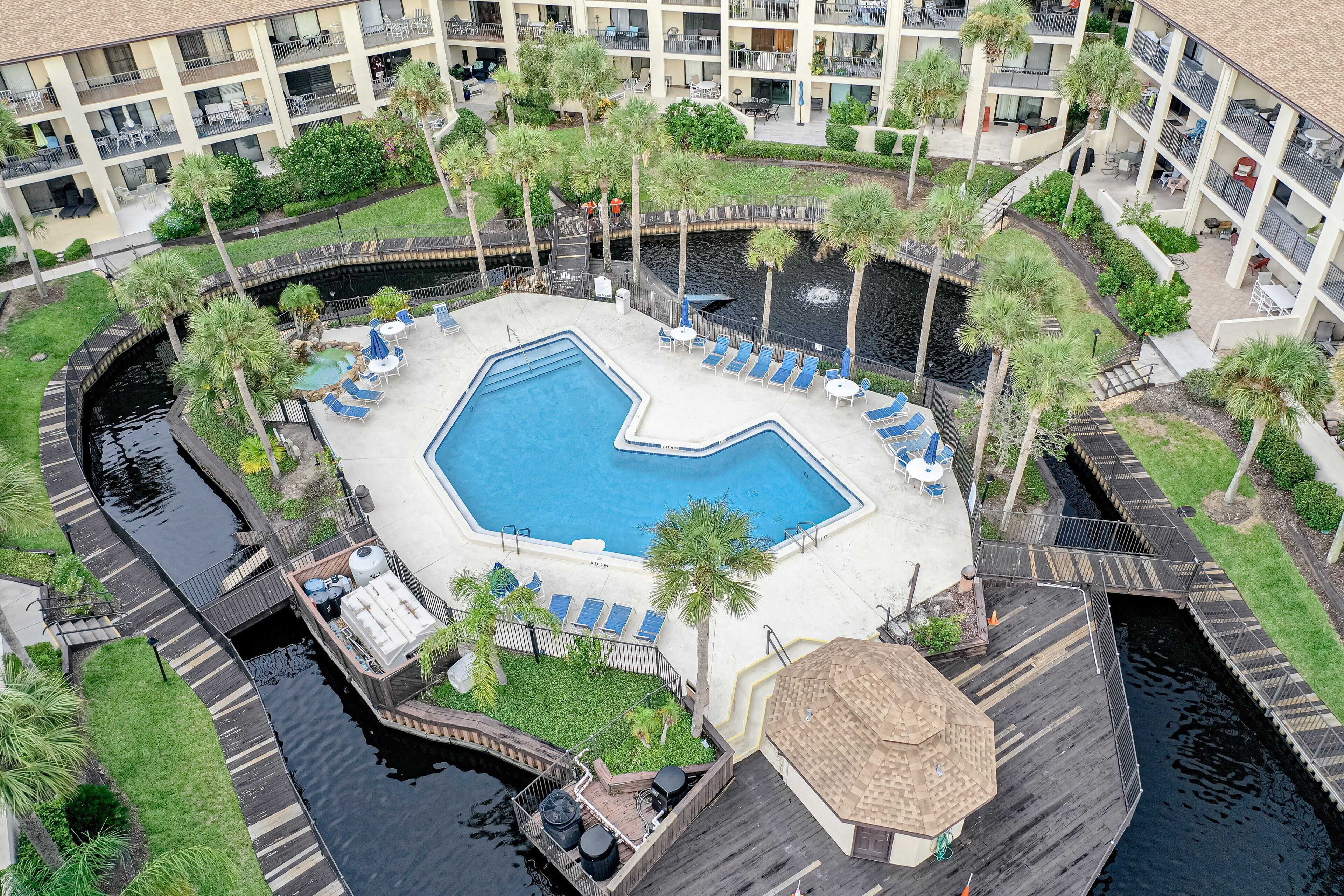 A pool area with lounge chairs, a small boat dock, and a water canal.