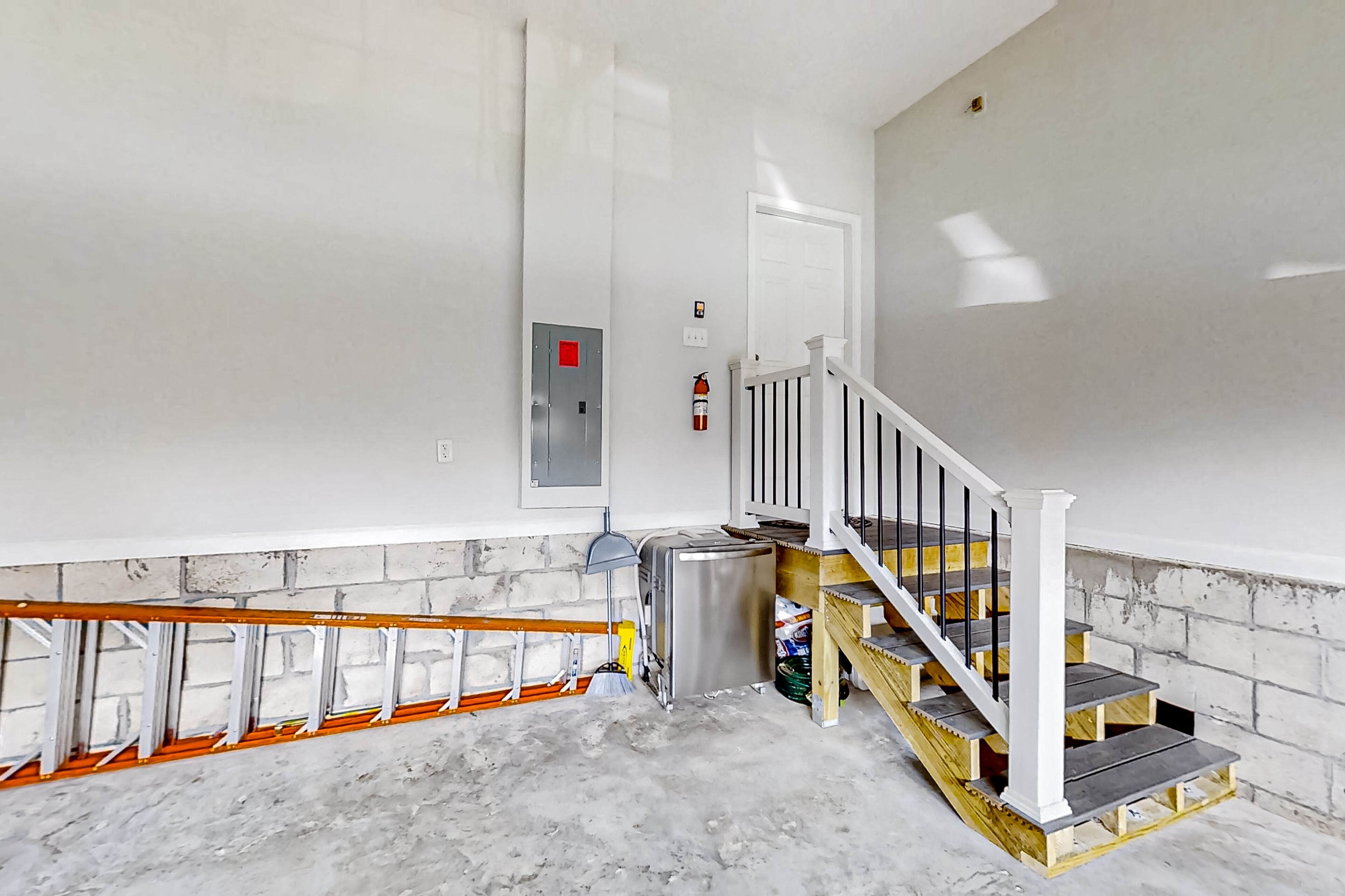 A staircase with a white railing and a fire extinguisher mounted on the wall.