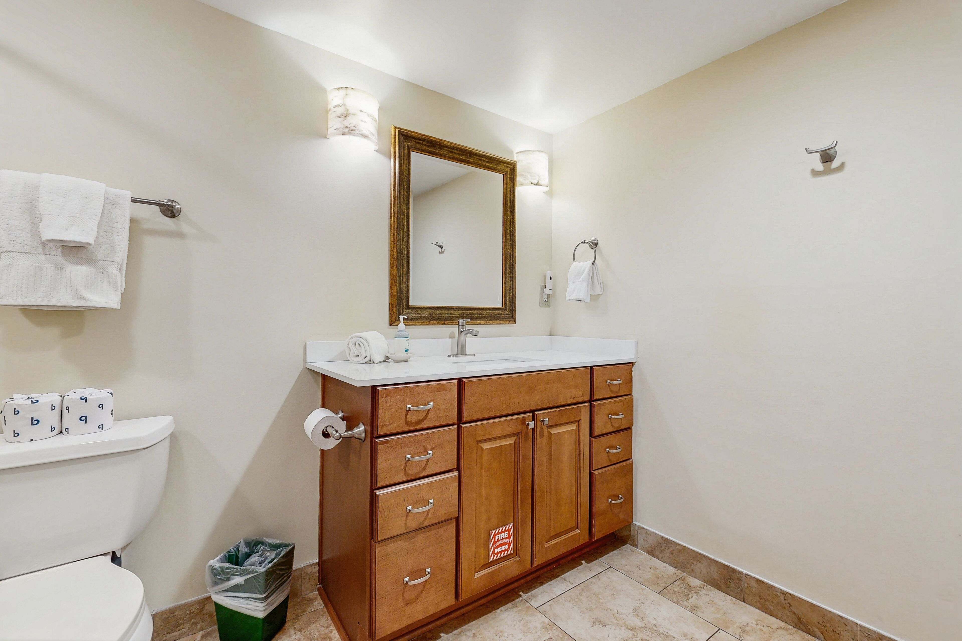 A bathroom with a wooden vanity, a sink, and a toilet.