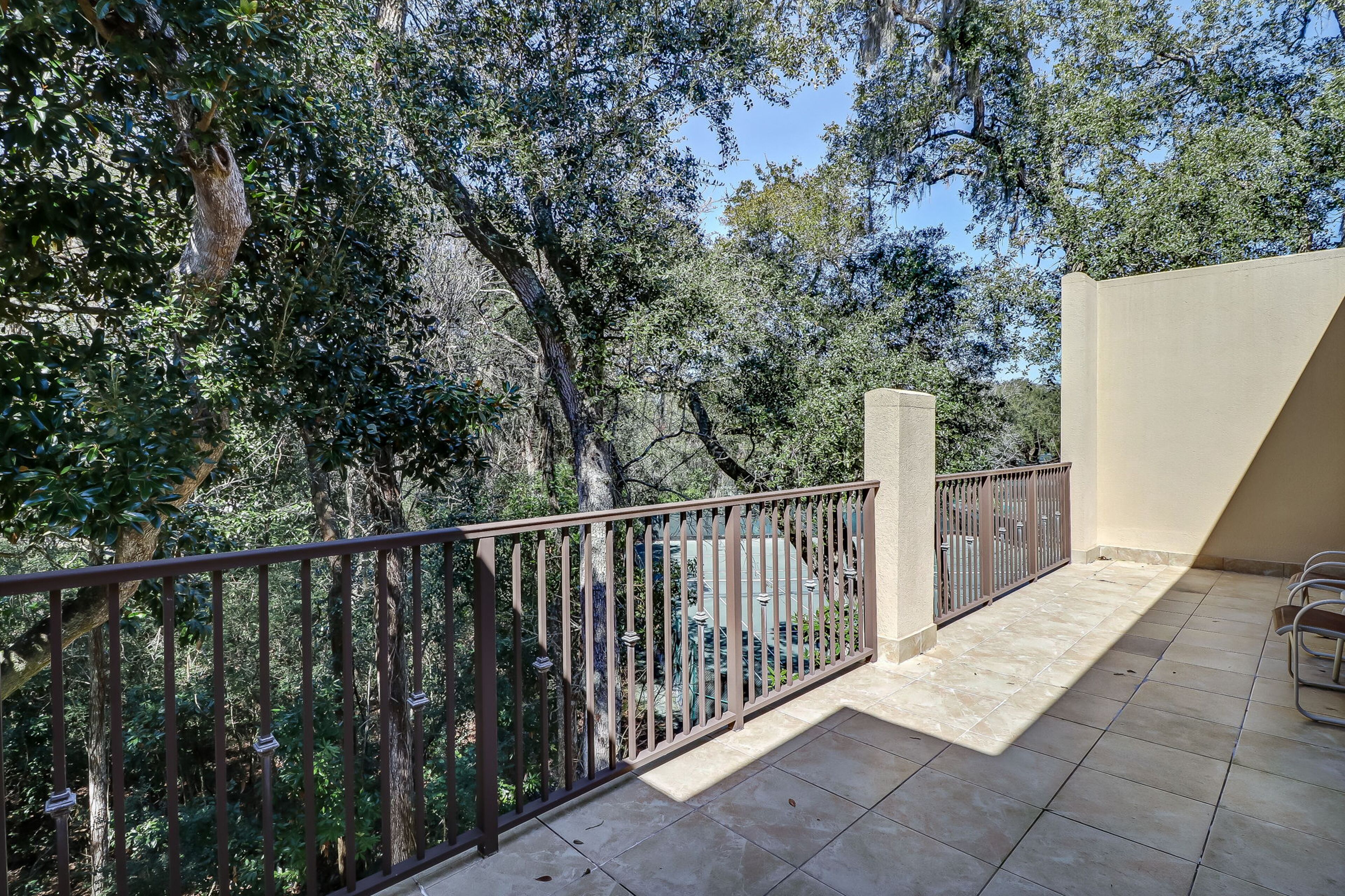 Un balcon donnant sur la verdure, avec un sol carrelé.