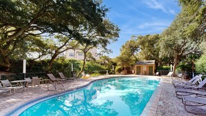 A swimming pool with lounge chairs and a small building in the background. - Newly Decorated, Oceanfront Townhouse With Patio, Wifi, W/D & Shared Pool (Fernandina Beach)