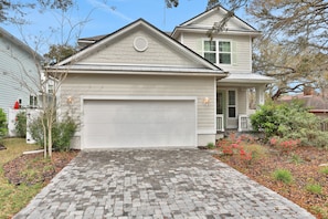 A two-story house with a garage and a brick driveway. - New Dog-friendly Home Near Vilano Beach With Private hot Tub, Grill, W/d, & AC (St. Augustine)