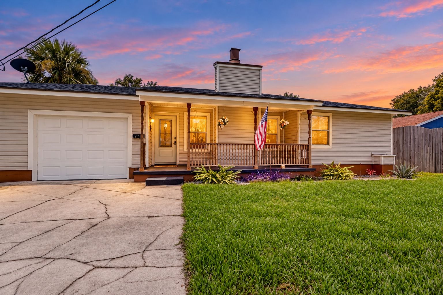 A single-story house with a front porch, a garage, and a well-maintained lawn.