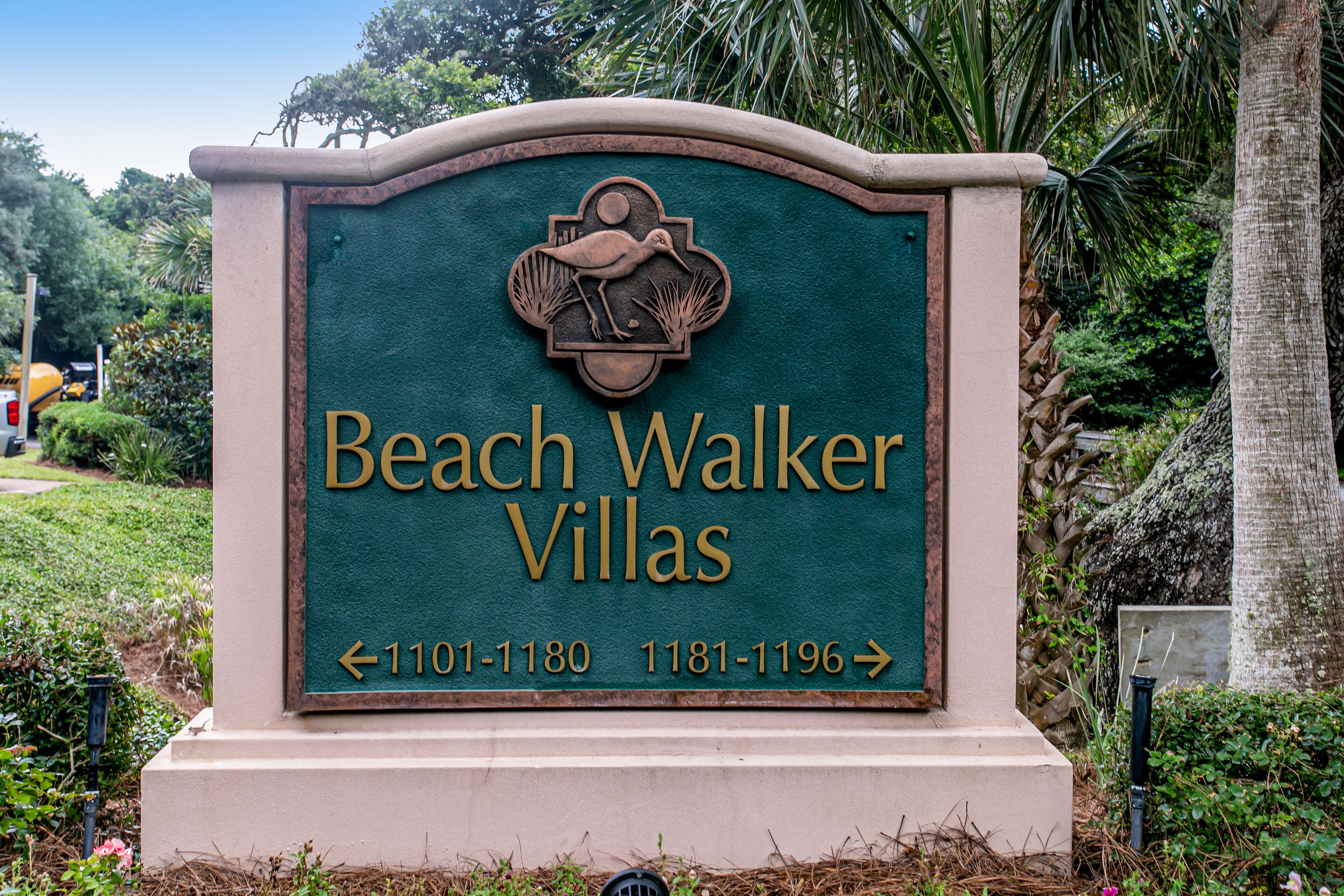 Un panneau indiquant l’emplacement de Beach Walker Villas, avec des flèches directionnelles et des numéros de téléphone.