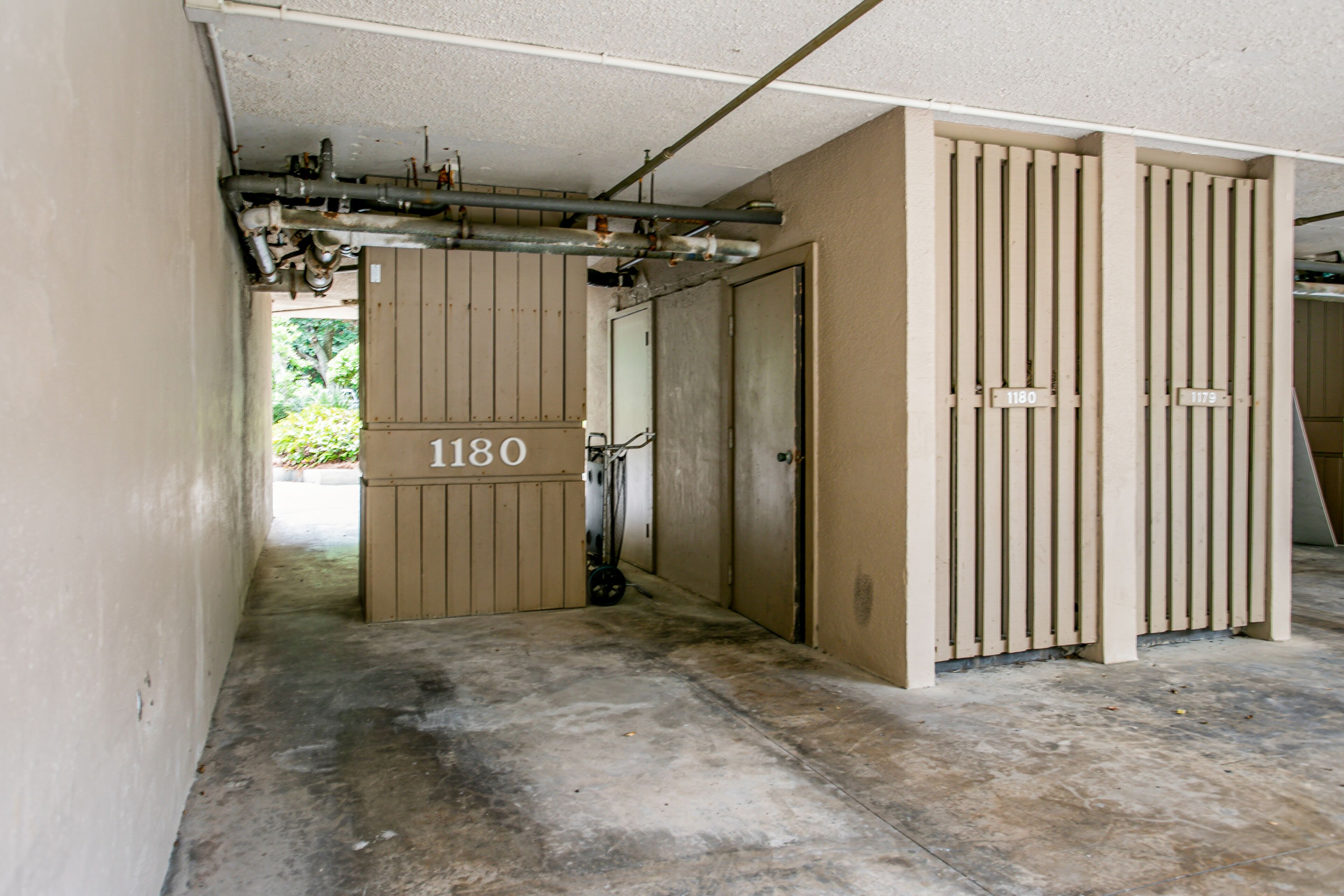Un couloir avec une porte portant l’inscription « 1180 » qui donne accès à une pièce.
