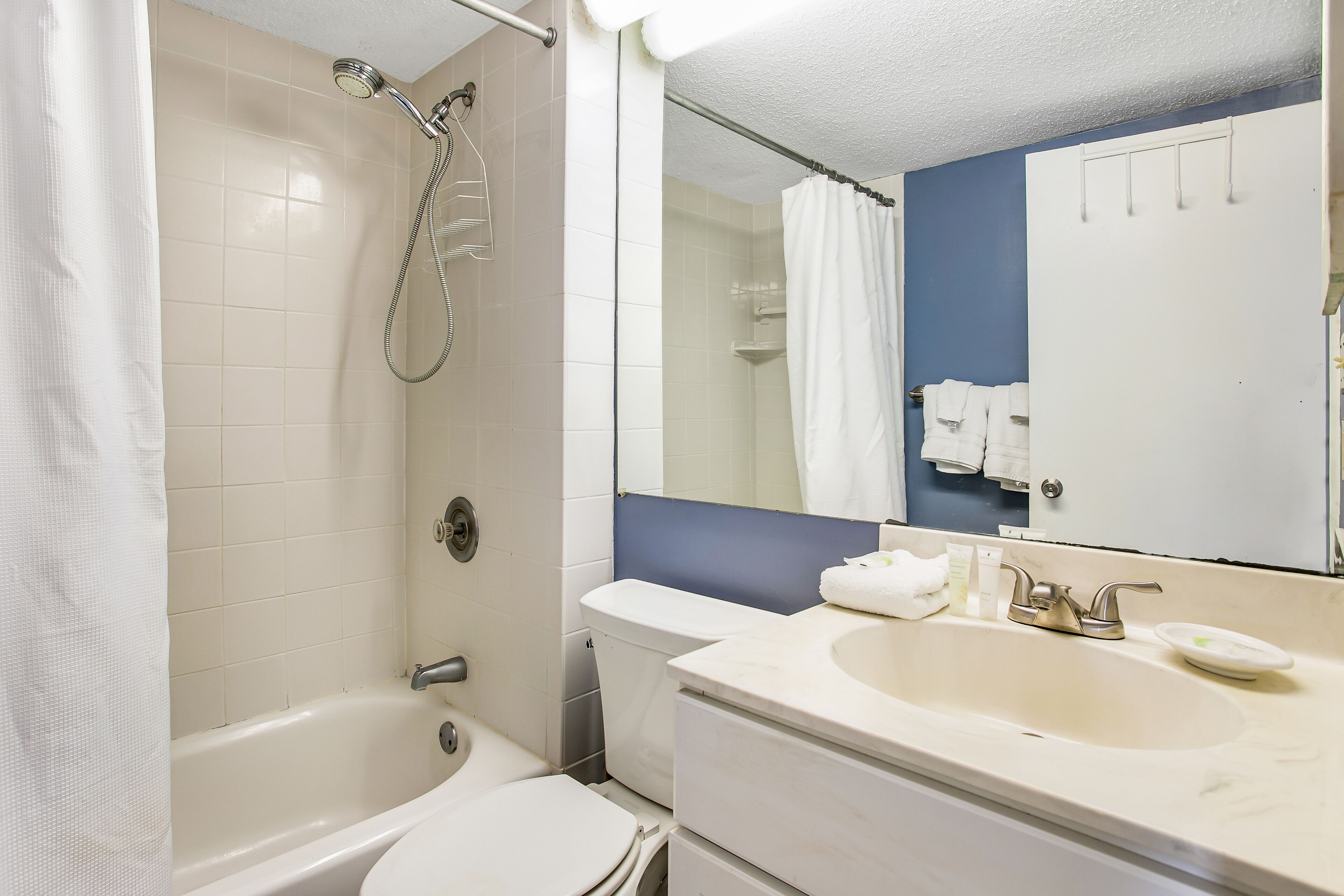 Baño con bañera, inodoro, lavabo y ducha con cortina.