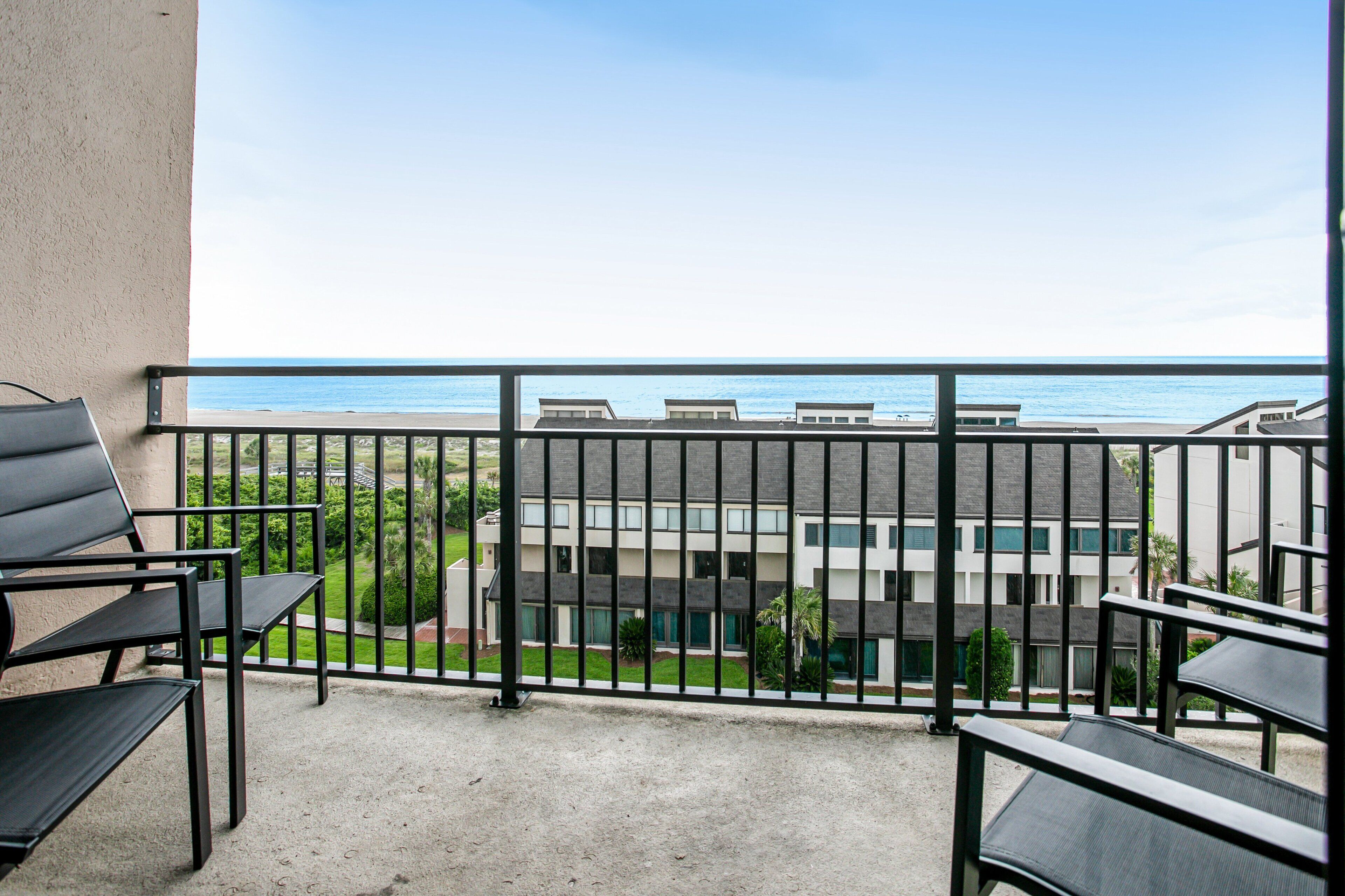 A balcony with a view of the sea and buildings.