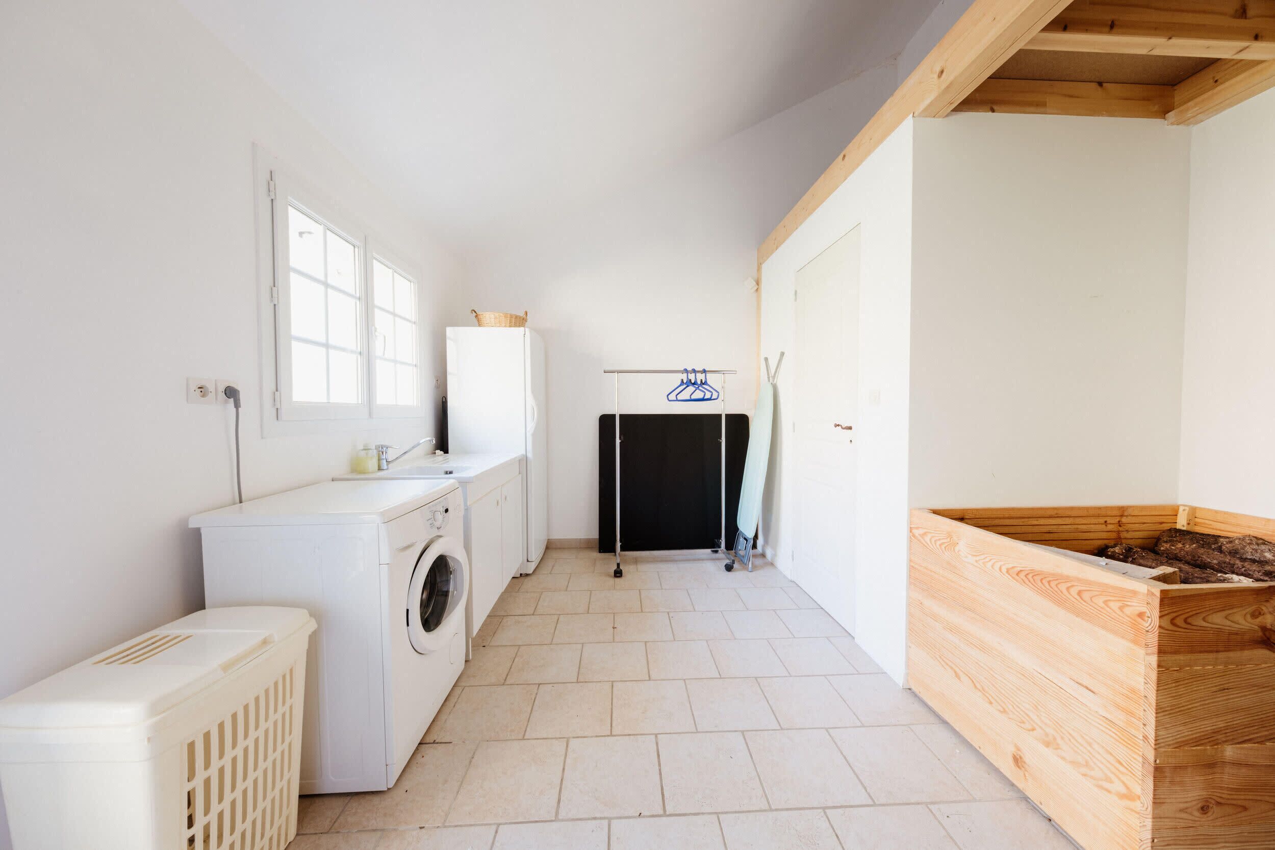 A laundry room with a washing machine, dryer, and drying rack.
