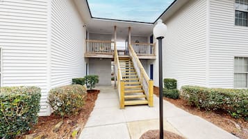 A multi-story building with a central staircase, outdoor lighting, and a covered walkway.