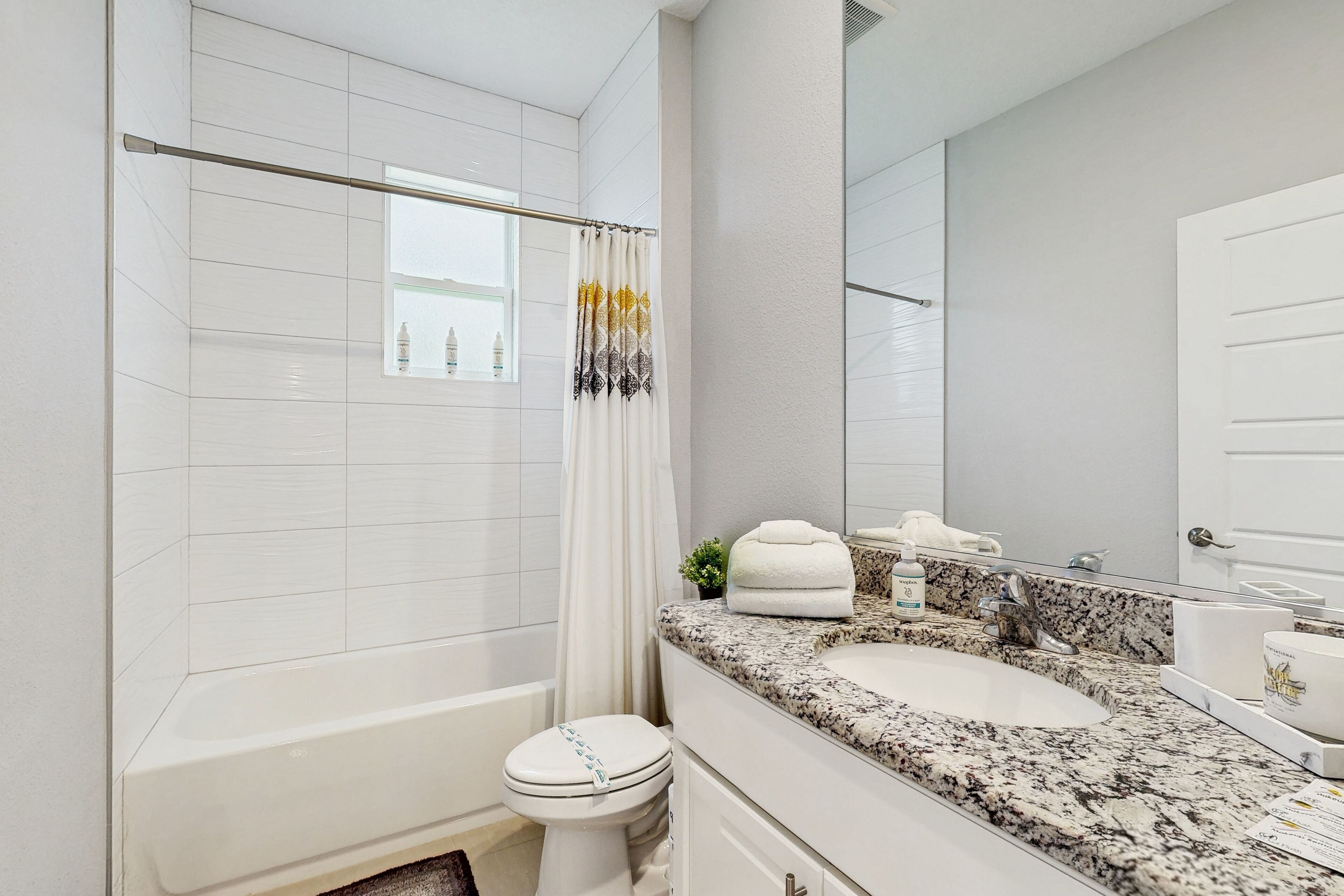 A bathroom with a bathtub, toilet, and sink.