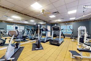 A gym with various exercise equipment, including treadmills, elliptical machines, and weight machines. - Spacious Condo With Pool, hot tub and Private Washer/dryer (St. Augustine)