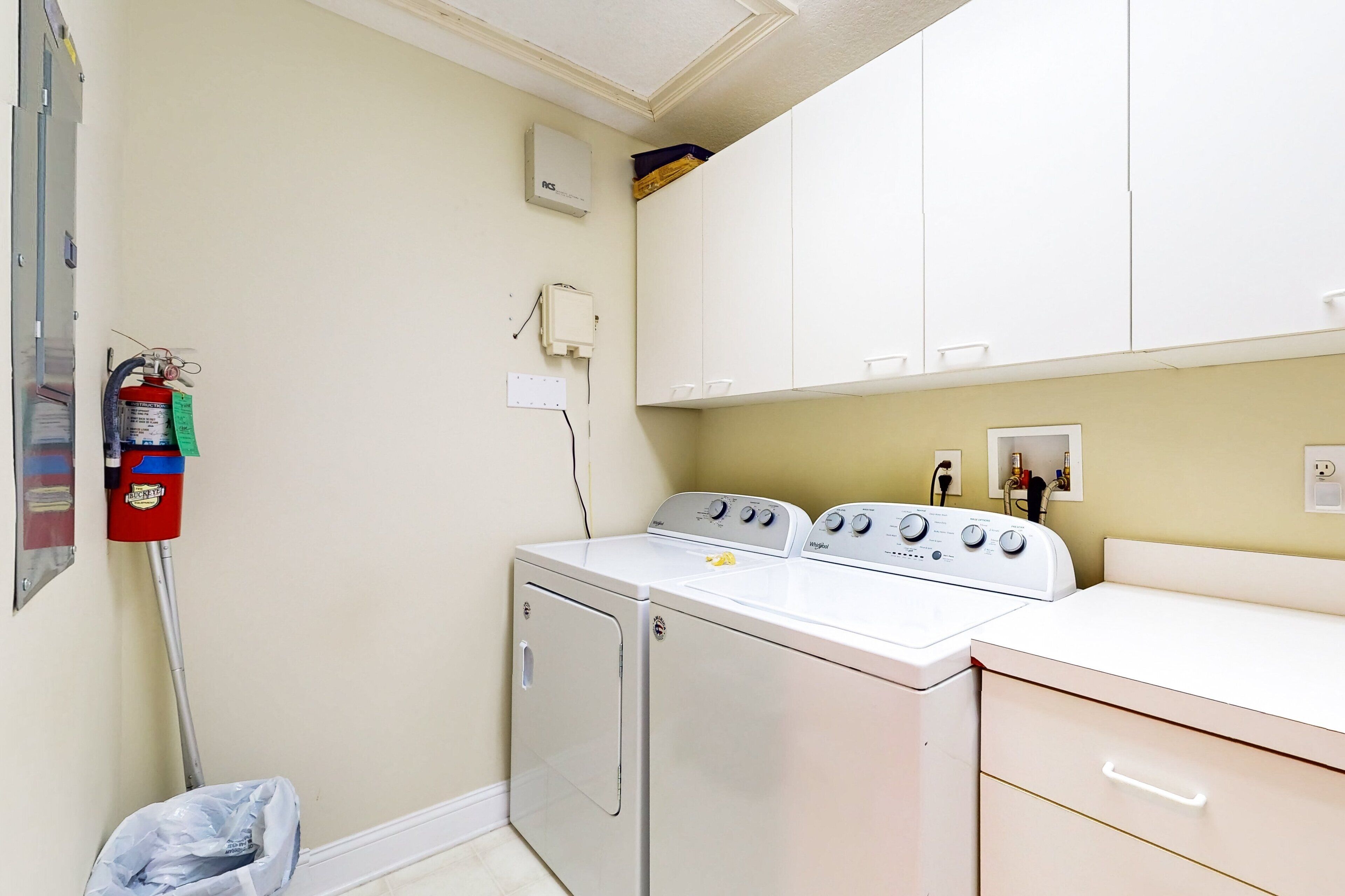 A laundry room with a washing machine, dryer, and stacked washer-dryer unit.