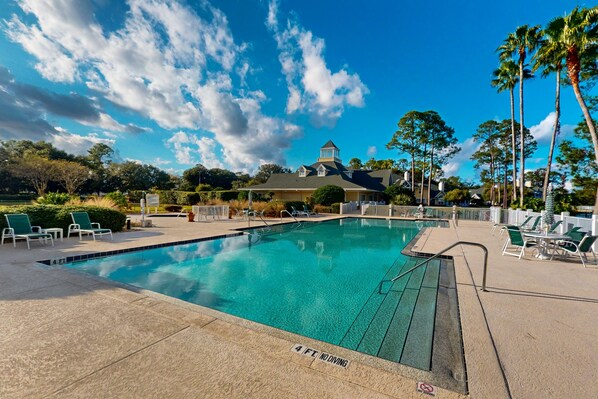 A swimming pool with lounge chairs and a building in the background. - Spacious Condo With Pool, hot tub and Private Washer/dryer (St. Augustine)