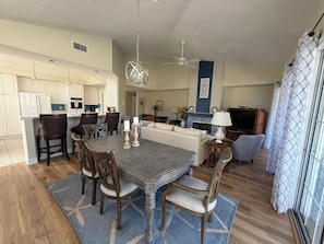 A spacious living area with a dining table, chairs, a sofa, and a TV. - Spacious Condo With Pool, hot tub and Private Washer/dryer (St. Augustine)