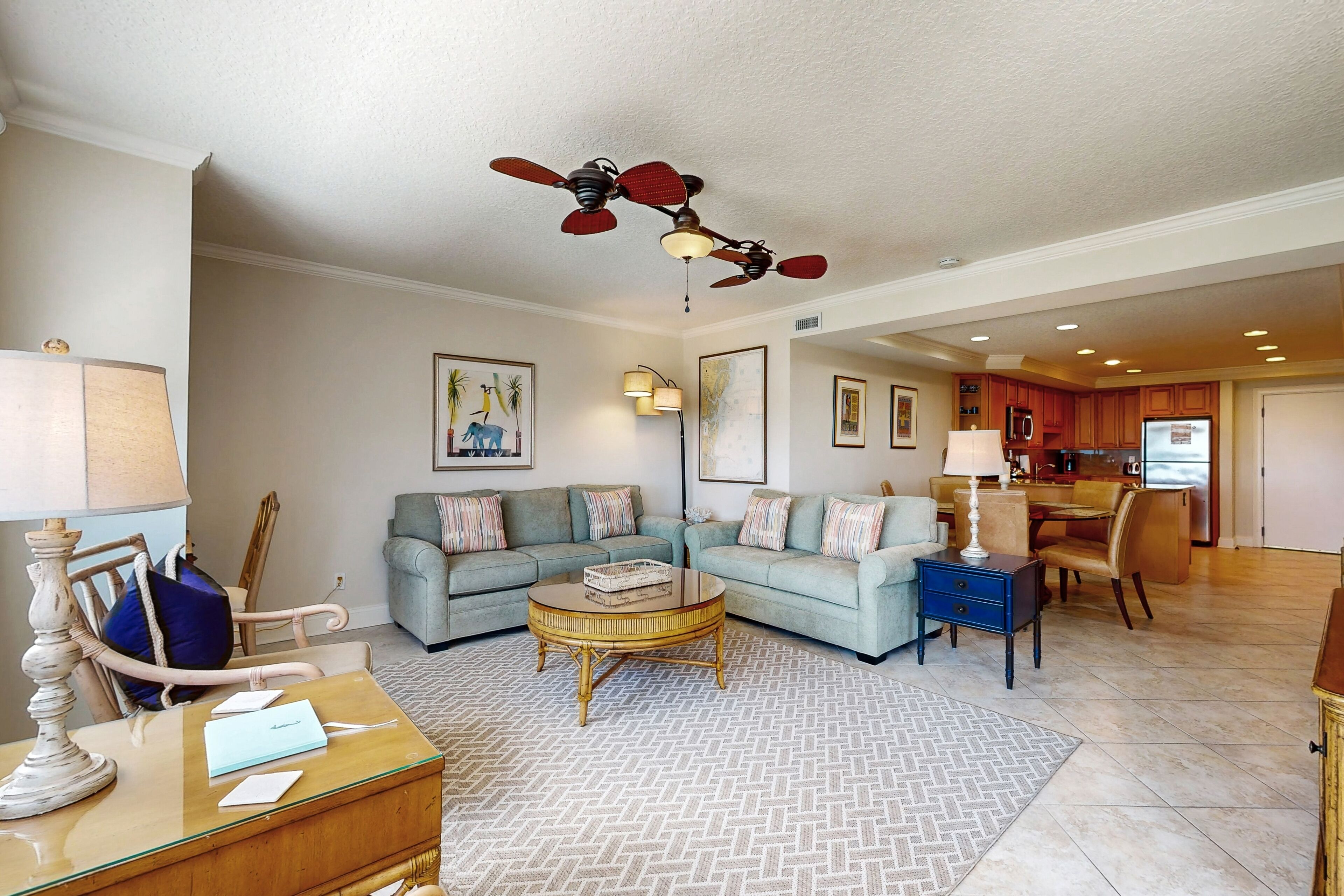 A spacious living room with a sectional sofa, a coffee table, and a ceiling fan.