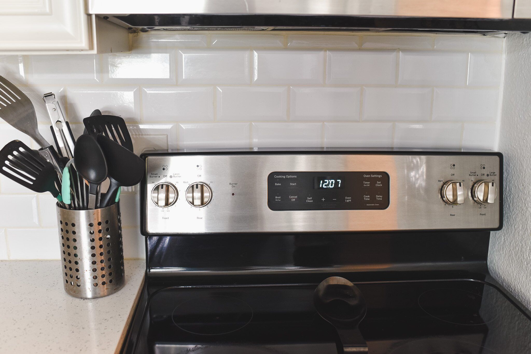 A stainless steel oven with a digital display, knobs, and a control panel with various settings.