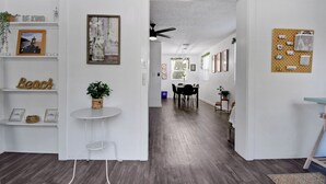 A modern interior with a dining area, white walls, wooden flooring, and a ceiling fan. - Downtown Jacksonville Retreat Pet-friendly With Hot Tub & Backyard Oasis (Jacksonville)