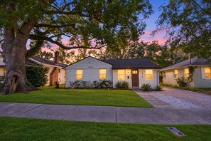 A two-story house with a well-maintained lawn and a large tree in the front yard. - Downtown Jacksonville Retreat Pet-friendly With Hot Tub & Backyard Oasis (Jacksonville)