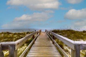 A wooden boardwalk leading to a beach with a clear sky and distant ocean view. - Ocean-view Condo With Pool, Balcony, AC & W/D - Walk to Beach & Near Downtown (Fernandina Beach)