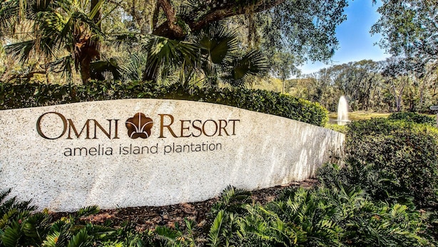 A sign for Omni Resort Amelia Island Plantation with lush greenery and a fountain in the background. - Oceanfront Condo With Spacious Balcony, Great Views, AC & Outdoor Pooloc (Fernandina Beach)
