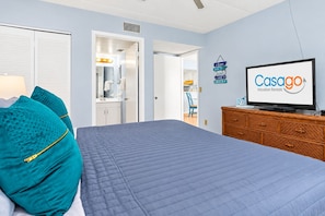 Une chambre d’hôtel équipée d’un lit, d’une télévision, d’une commode et d’un panneau indiquant « Casago Vacation Rentals ».