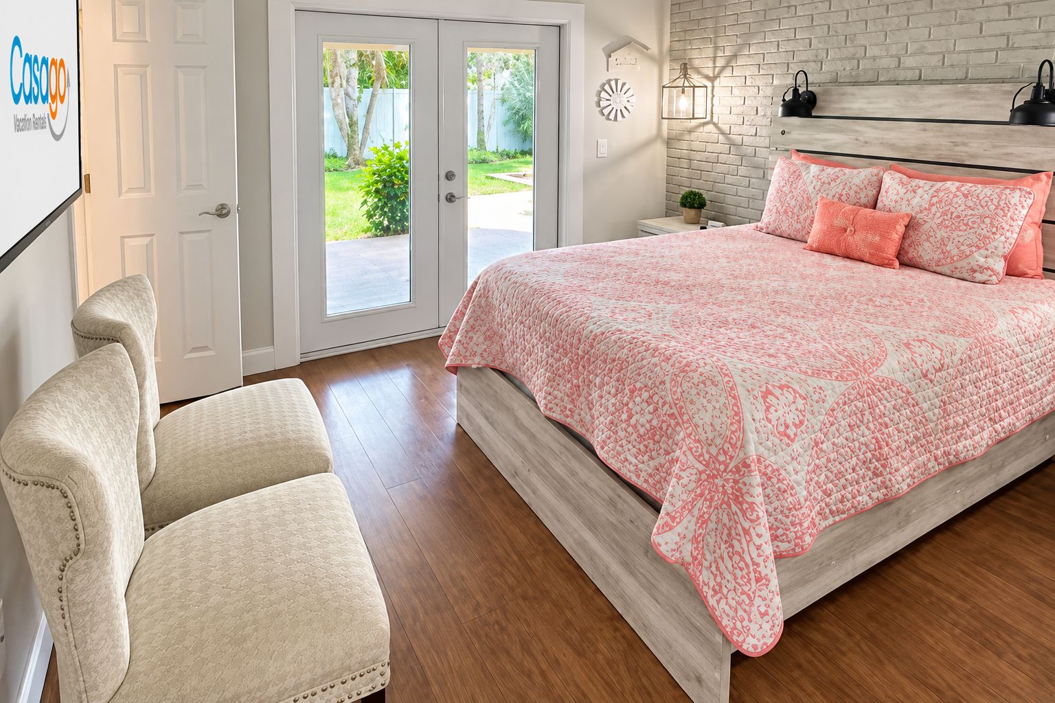 A bedroom with a bed, a chair, a nightstand, and a door leading to a balcony.