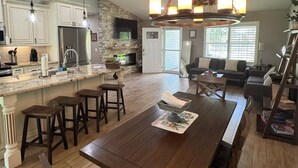 A spacious kitchen with a large island, wooden bar stools, and a built-in stove. - Spacious Coastal Home in St. Augustine Pool, Outdoor Oasis & Private Suite (St. Augustine)