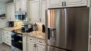 A modern kitchen with white cabinetry, stainless steel appliances, and a granite countertop. - Spacious Coastal Home in St. Augustine Pool, Outdoor Oasis & Private Suite (St. Augustine)
