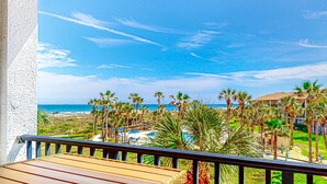 A balcony with a view of the beach, palm trees, and a pool area. - Recently Updated Resort Condo With 2 Pools, 2 Balconies, Ocean Views, Bbq, & W/D (St. Augustine)