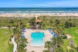 An aerial view of a beach resort with a swimming pool, palm trees, and a beach in the background. - Recently Updated Resort Condo With 2 Pools, 2 Balconies, Ocean Views, Bbq, & W/D (St. Augustine)
