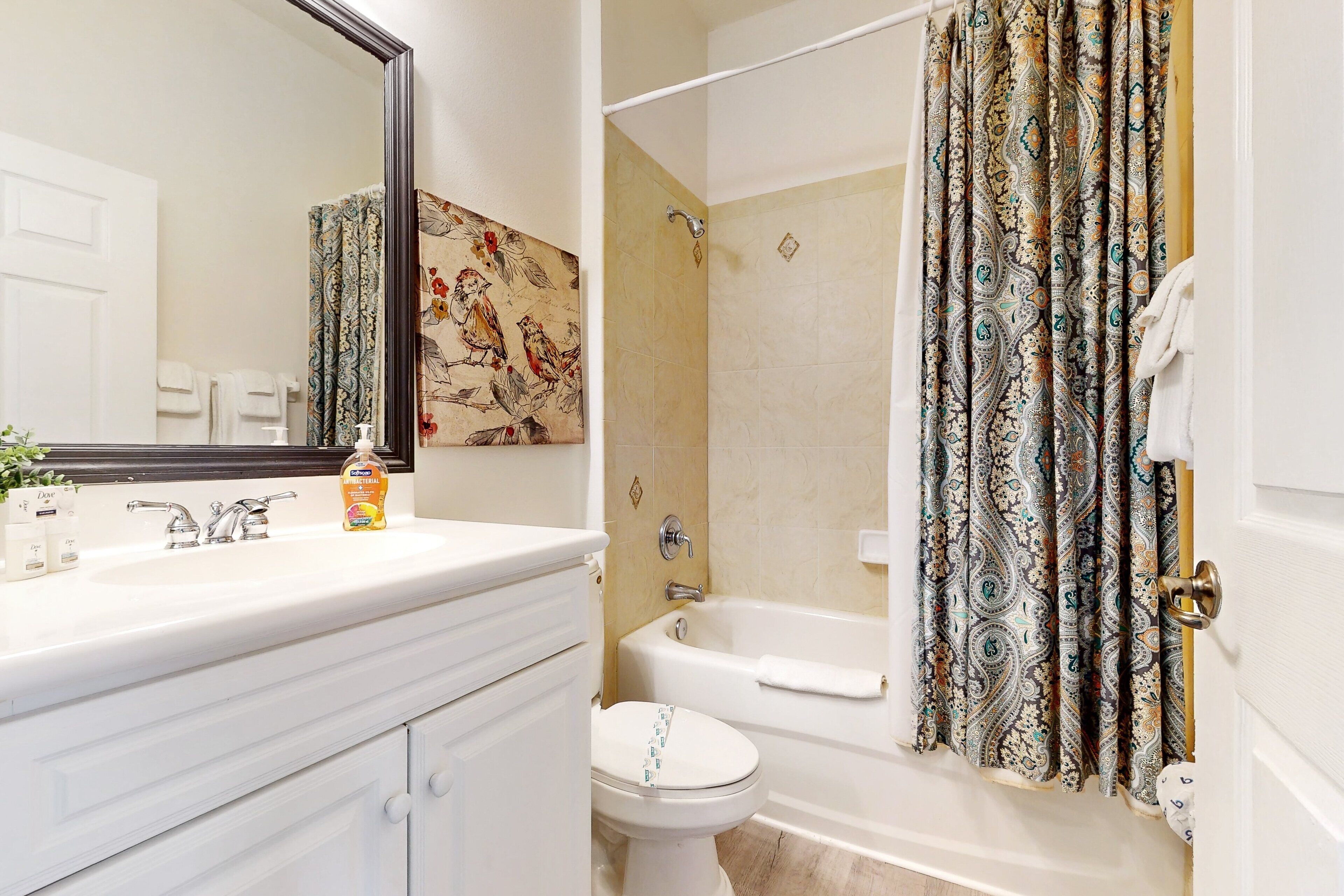 A bathroom with a white sink, a toilet, and a bathtub.