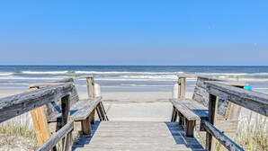 A wooden boardwalk leading to the beach with waves in the background. - Oceanfront Condo With Beach Access, Patio, Outdoor Pools, Tennis Court, W/d, AC (St. Augustine)