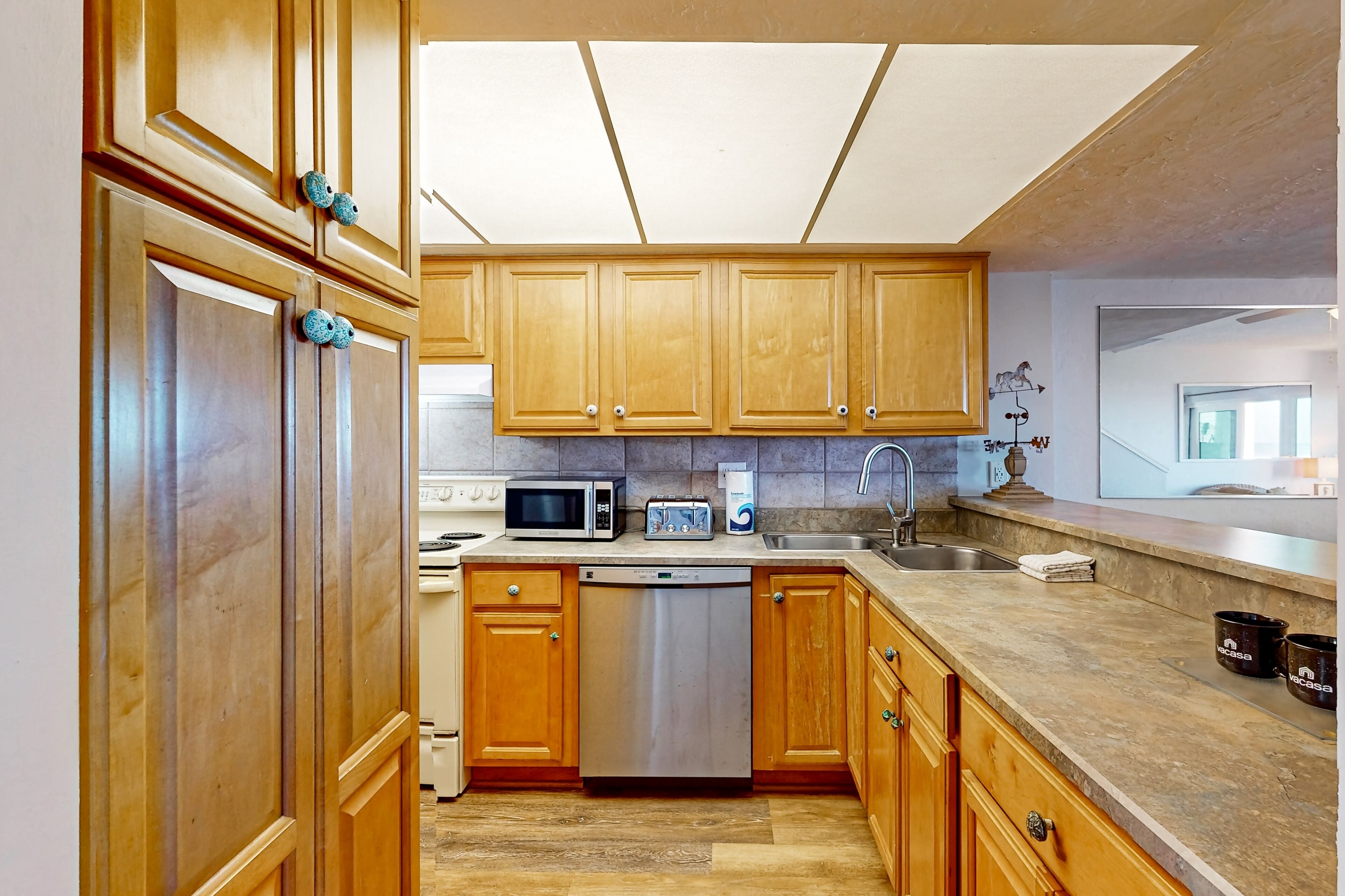 A kitchen with wooden cabinets, a microwave, a dishwasher, and a sink.