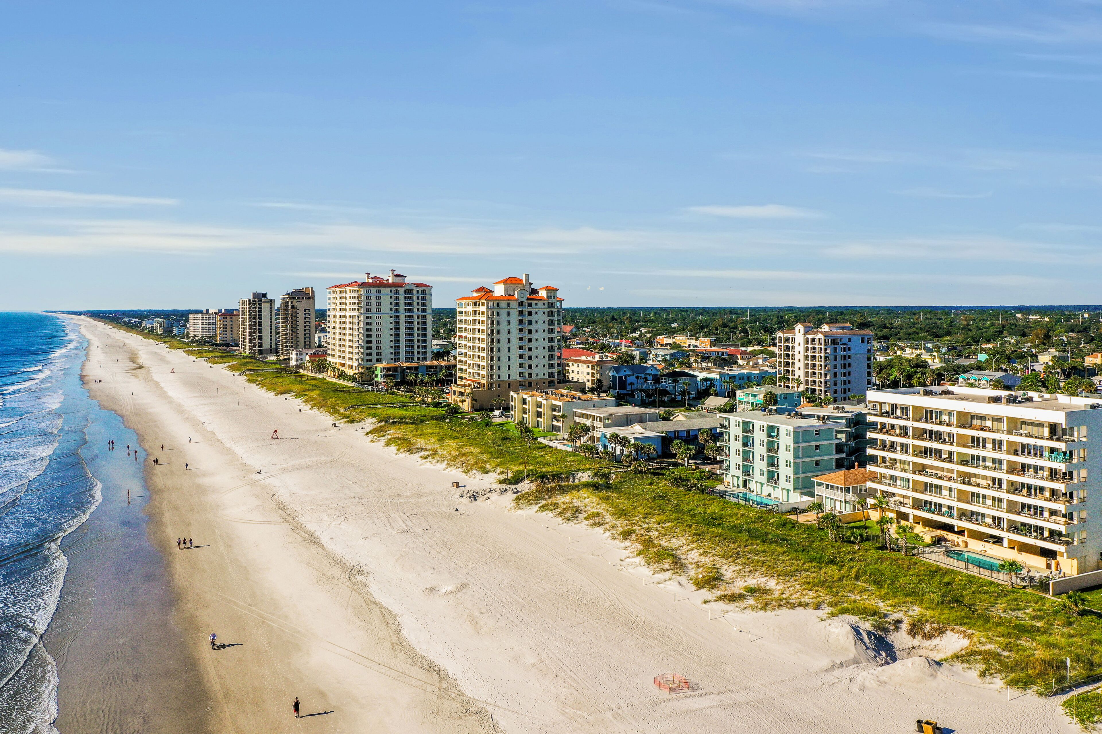 A beachfront hotel with multiple high-rise buildings, a sandy beach, and ocean views.