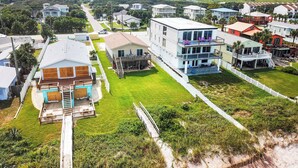 Un quartier résidentiel avec des maisons, une pelouse verdoyante et une plage en arrière-plan.