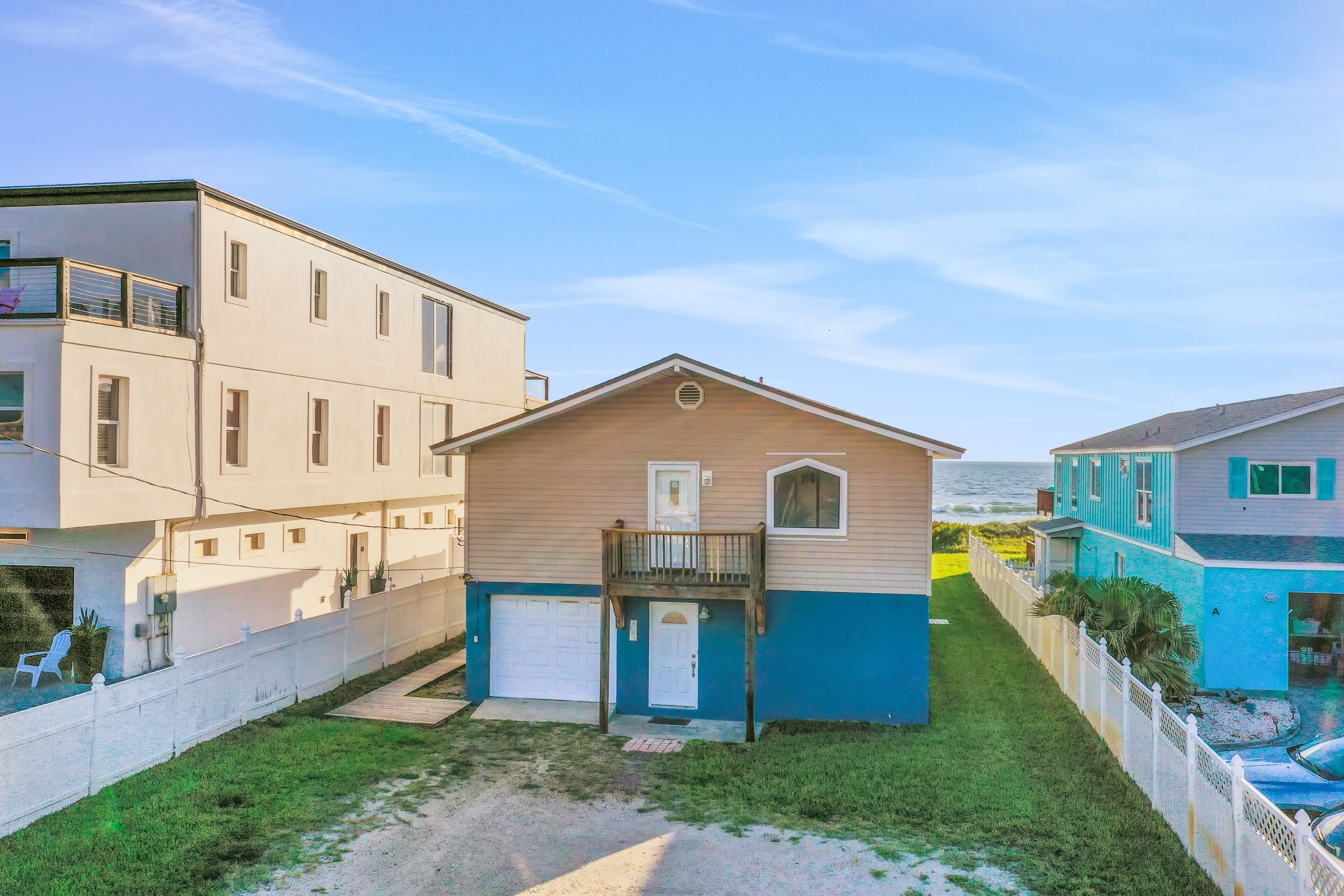 A two-story house with a balcony, a garage, and a small front yard.