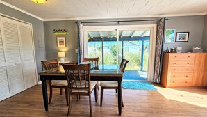 A dining area with a table and chairs, a lamp, and a view through a glass door to the outdoors. - Private House Walk to the Beach & Parks! Large Decks, Family Vacation! Hammock Beach (Palm Coast)