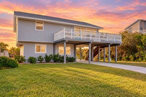 A two-story house with a covered porch and a balcony. - Serene 2-level Home With Wifi & Deck - Walk to Beach, 1 dog Welcome (St. Augustine)