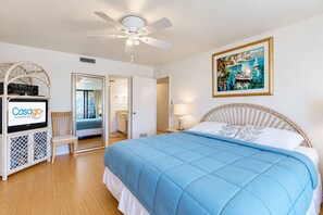 A hotel room with a bed, a television, a ceiling fan, and a painting on the wall. - Oceanfront Condo w/ Private Balcony & Stunning View - Boardwalk to Beach (St. Augustine)