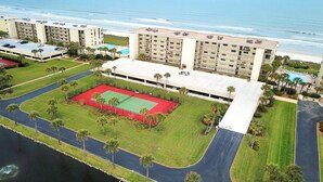 A hotel with multiple floors, a tennis court, and a view of the beach. - Sand Dollar III 605 (St. Augustine)
