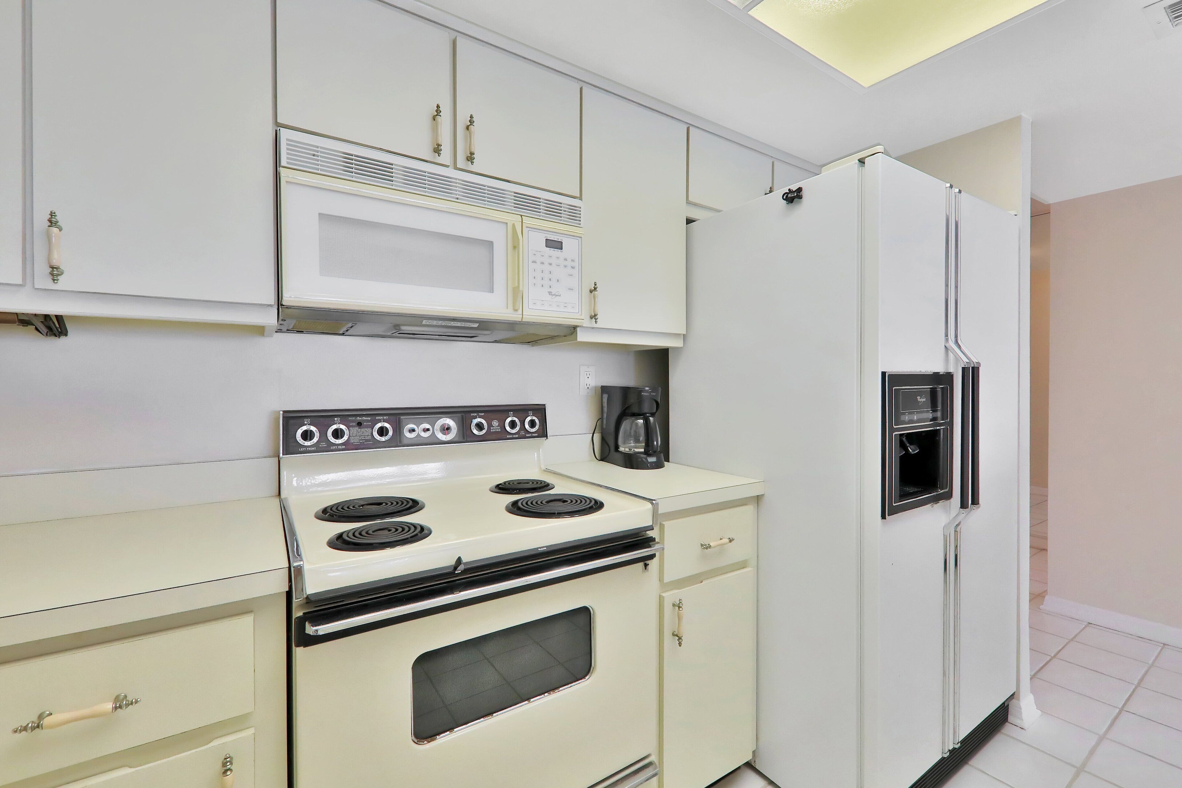 A kitchen with a stove, microwave, and refrigerator.