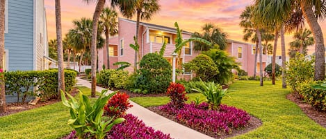 A residential area with a row of houses, a pathway, and well-maintained gardens.