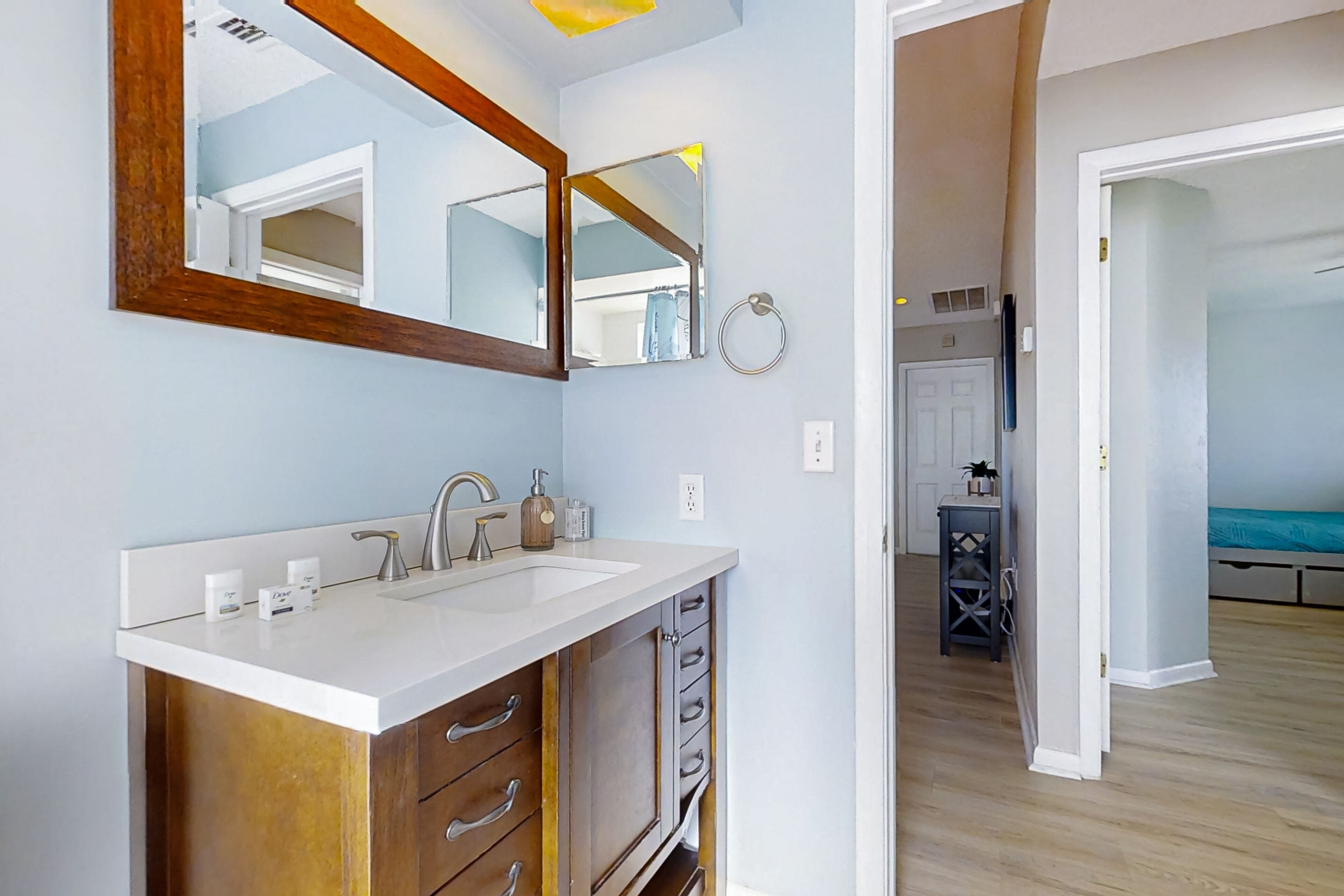 Un baño moderno con lavamanos doble, armarios de madera y un espejo grande.