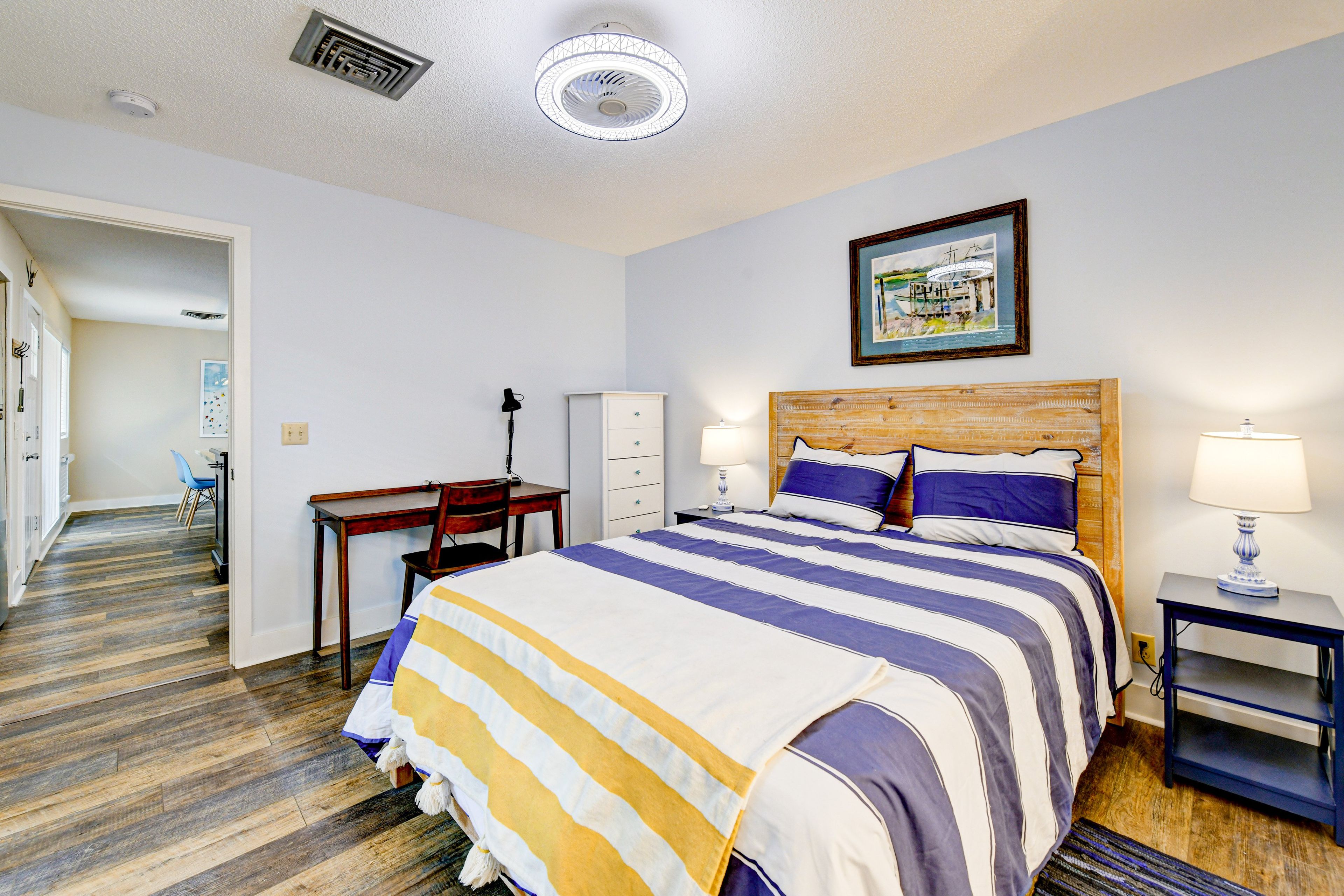 Una camera d'albergo con un letto, una scrivania, una sedia e una testiera in legno.