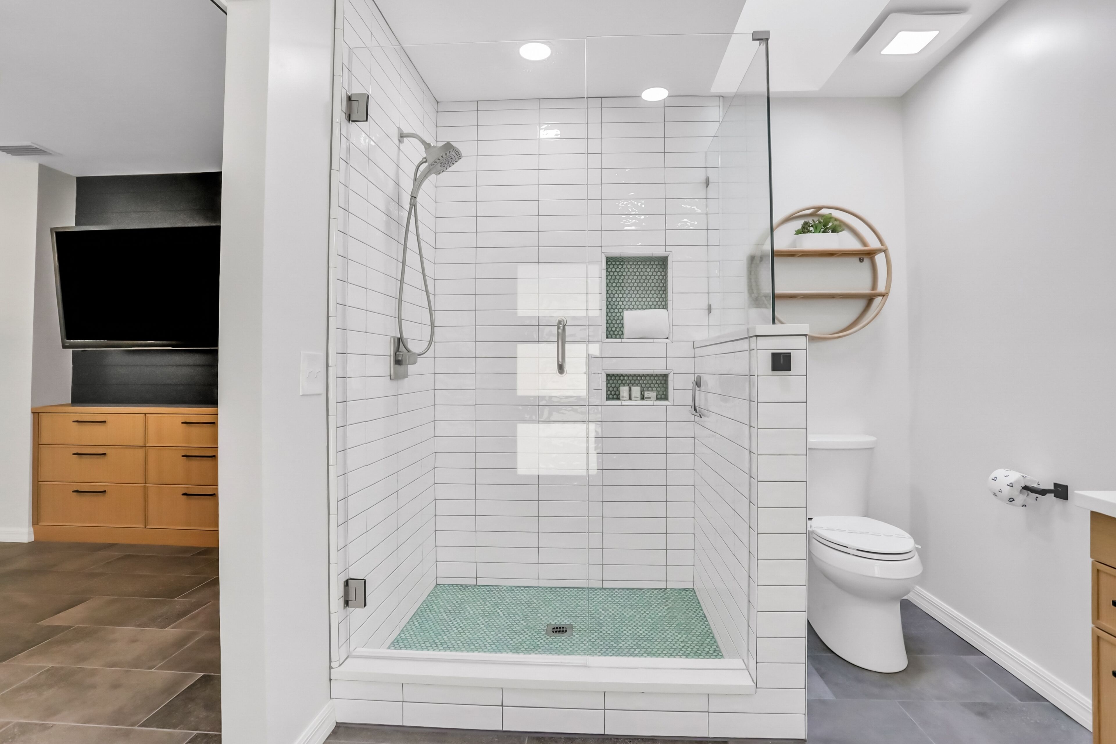 Een moderne badkamer met douche, toilet en wastafel.