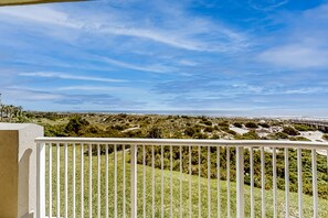 A balcony with a view of a coastal landscape, including sand dunes and a boardwalk. - Oceanfront, 2nd-floor Condo With Balcony, Hdtvs, Wifi, AC & Shared Pool (Fernandina Beach)