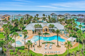 A resort with a large swimming pool, palm trees, and a view of the ocean. - Spacious Fourth-floor Beachfront Condo With Pools, hot Tub, Fitness Room (Palm Coast)