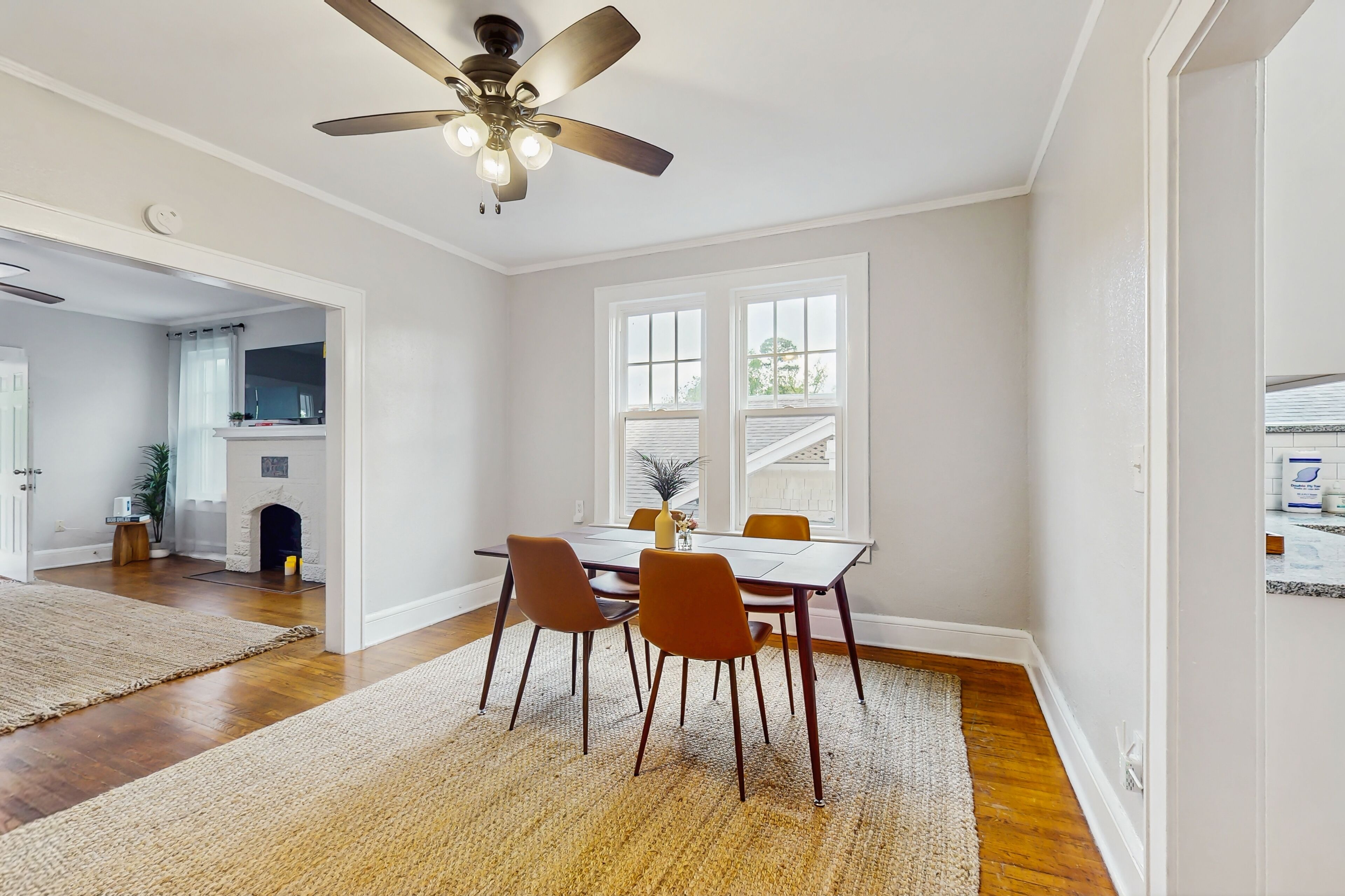 A dining area with a table, chairs, and a ceiling fan.